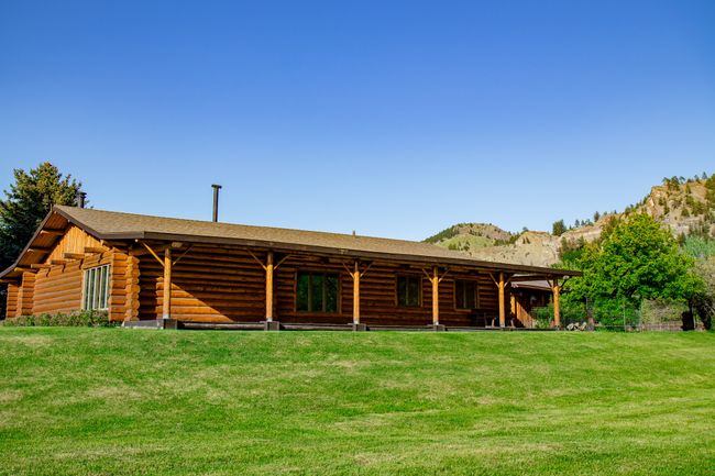Back of house with log exterior, a mountain view, and a yard | Image 9