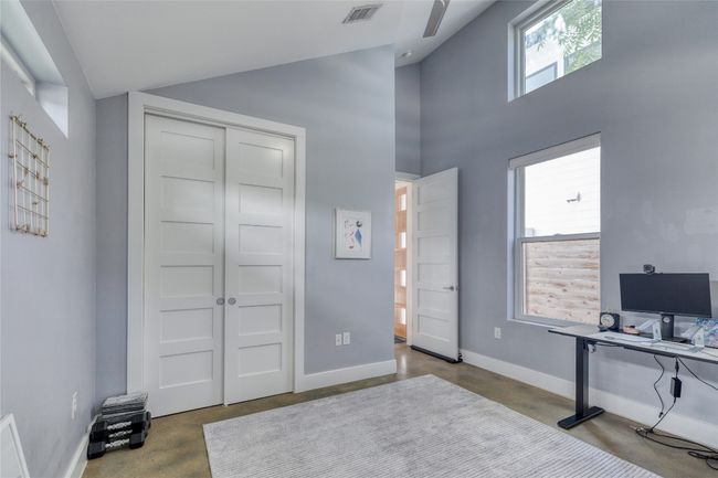 Office featuring concrete floors, baseboards, and high vaulted ceiling | Image 17