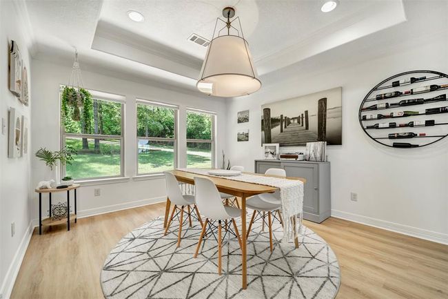 Enjoy formal dining with a picturesque view overlooking the expansive front lawn, adorned with lush greenery and mature shade trees | Image 9