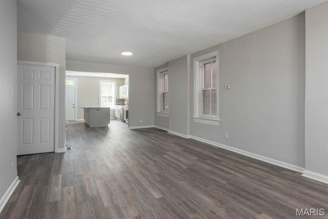 Unfurnished living room featuring dark wood-style floors and a textured ceiling | Image 6