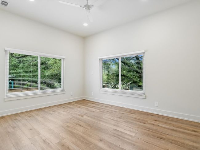 Unfurnished room with light wood-style floors, a healthy amount of sunlight, visible vents, and a ceiling fan | Image 14