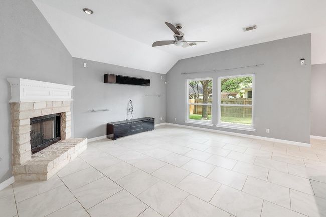 Unfurnished living room featuring visible vents, baseboards, a ceiling fan, and lofted ceiling | Image 4