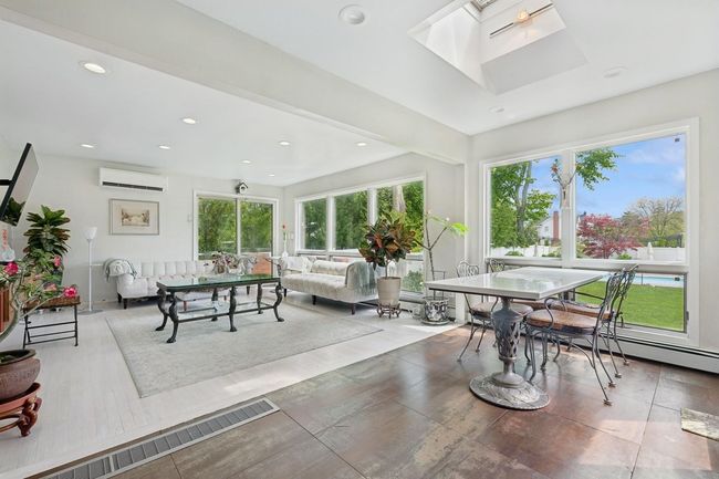Sunroom / solarium featuring healthy amount of natural light, an AC wall unit, and a skylight | Image 13