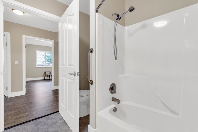 Bathroom featuring toilet, shower / bathtub combination, baseboards, and wood finished floors | Image 25