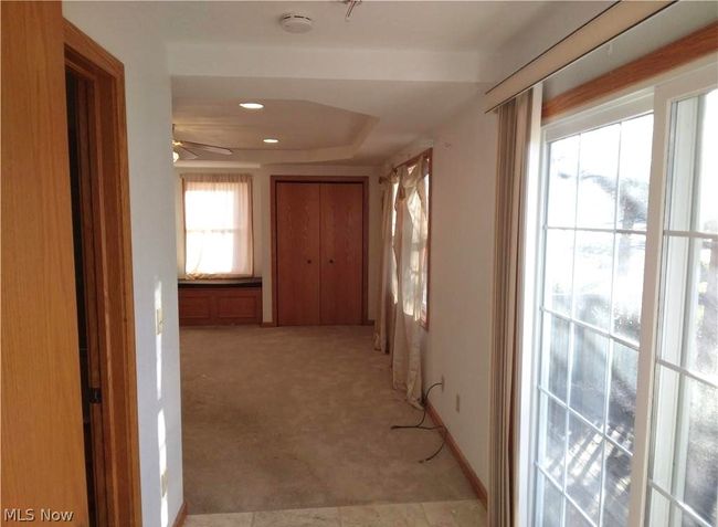 Corridor featuring a raised ceiling and light colored carpet | Image 11