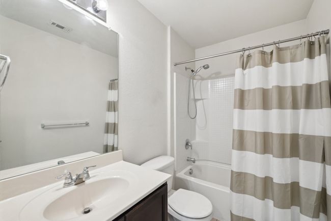 Bathroom with shower / tub combo with curtain, visible vents, toilet, and vanity | Image 17