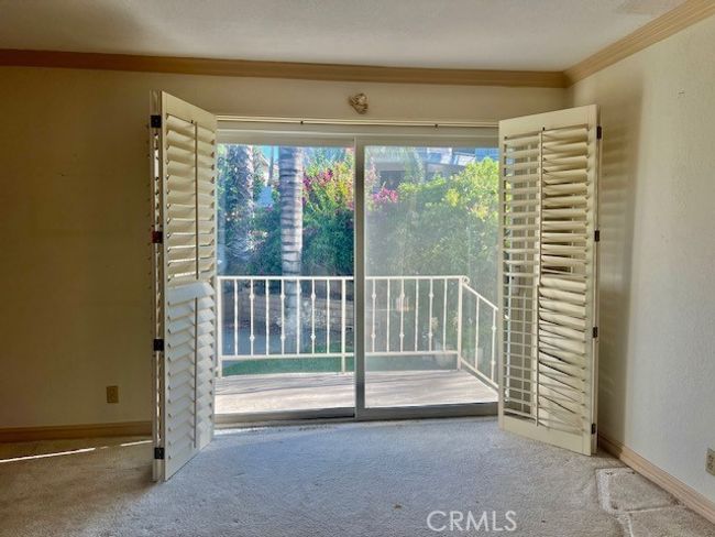 Living room sliders looks at yard and has shutter doors | Image 13