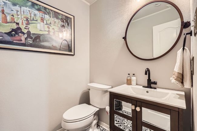 Spacious 1/2 Bathroom with vanity and ornamental molding | Image 17