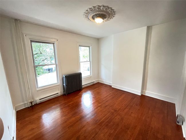 Spare room featuring a baseboard heating unit, radiator, and dark wood-type flooring | Image 6