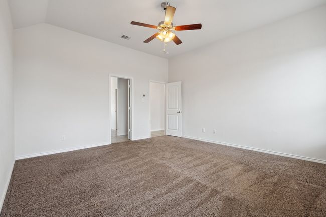 Carpeted spare room featuring ceiling fan and vaulted ceiling | Image 16
