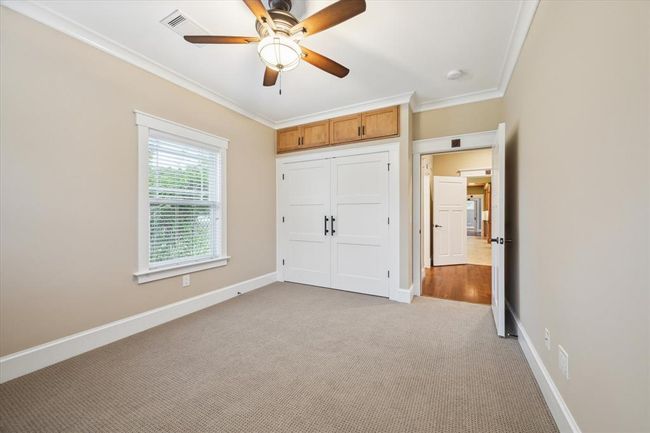 CUSTOM CLOSET WITH ADDITIONAL STORAGE ABOVE. BOTH SECONDARY BEDROOMS ARE ENTERED THROUGH THE LIBRARY | Image 38