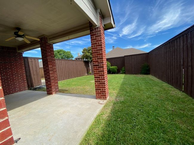 View of yard featuring a ceiling fan and a patio | Image 26