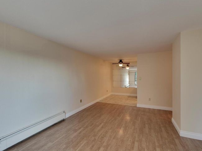 Spare room with light wood finished floors, baseboards, a baseboard heating unit, and ceiling fan | Image 7