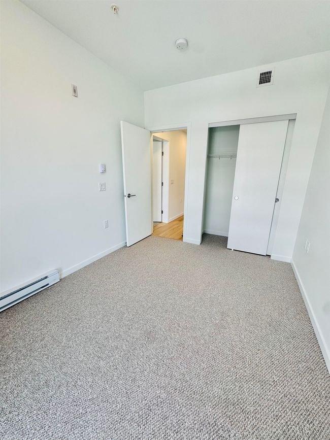 Unfurnished bedroom with a closet, visible vents, baseboards, and light carpet | Image 13