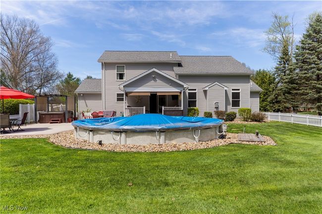 Rear view of house with partial inground pool and hot tub. | Image 38
