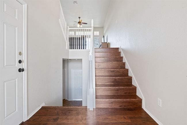 Staircase featuring visible vents, wood finished floors, and a ceiling fan | Image 5
