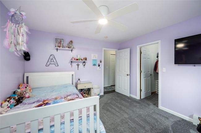 Carpeted bedroom with baseboard heating and ceiling fan | Image 26