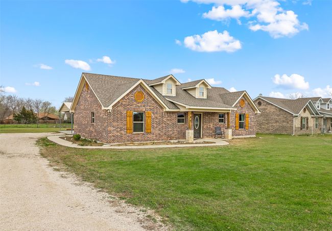 View of front facade featuring a front lawn, driveway, brick siding, and roof with shingles | Image 22