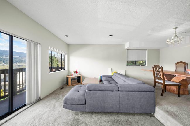 Living area featuring carpet flooring, an inviting chandelier, and a textured ceiling | Image 24