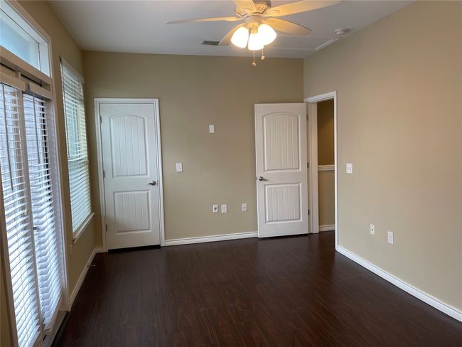 Unfurnished bedroom featuring multiple windows, wood finished floors, and ceiling fan | Image 16