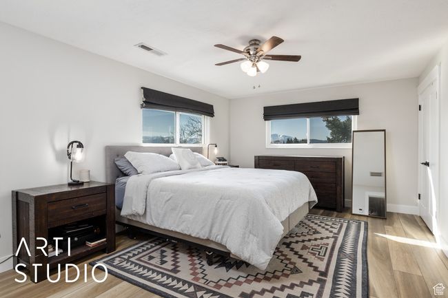 Bedroom featuring wood finished floors, visible vents, a ceiling fan, and multiple windows | Image 23