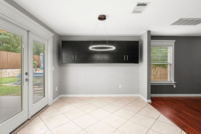 Unfurnished dining area with light tile patterned flooring and baseboards | Image 14