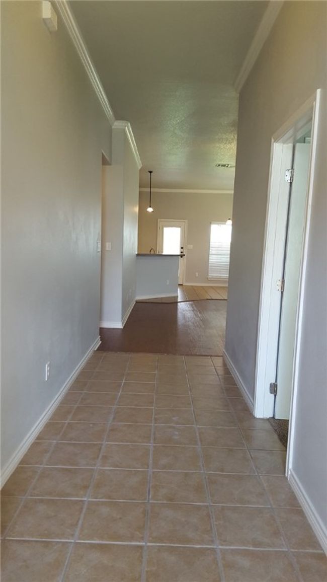 Hall featuring crown molding, tile patterned floors, and a textured ceiling | Image 15