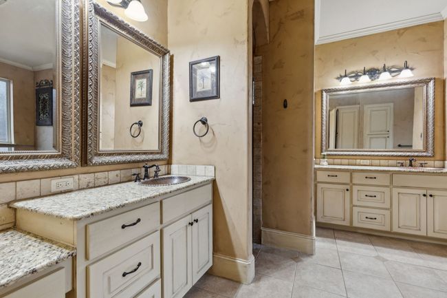 Bathroom featuring two Granite vanities, tile patterned floors, a copper sink, and crown molding | Image 13