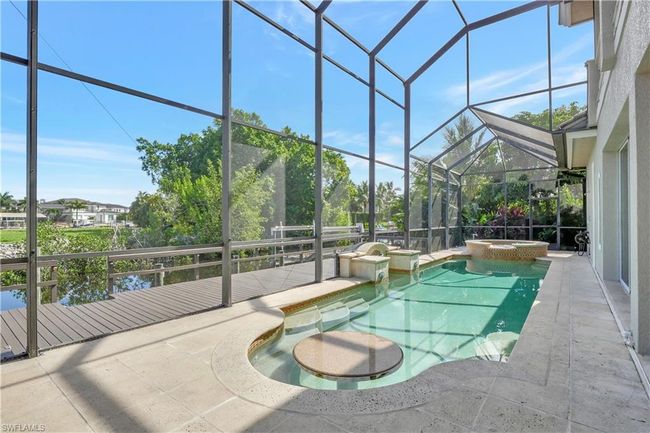 View of pool with a patio, a lanai, and a pool with connected hot tub | Image 34