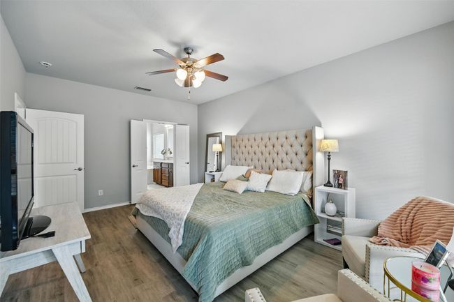 Bedroom with wood finished floors, a ceiling fan, and ensuite bath | Image 30