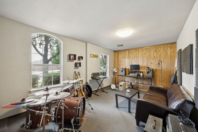 Fully finished and creatively designed, the 3rd garage bay provides the ultimate hangout or hobby zone, complete wood-paneled wall that's easily removed to reveal the garage door. | Image 29