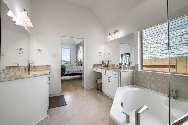 Bathroom with natural light, two vanities, lofted ceiling, and walk in closet, separate toilet | Image 22