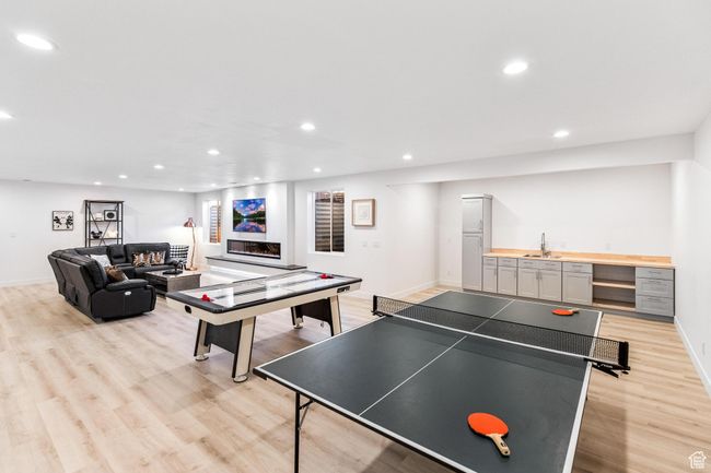 Rec room with light wood-style flooring, a sink, baseboards, and recessed lighting | Image 40