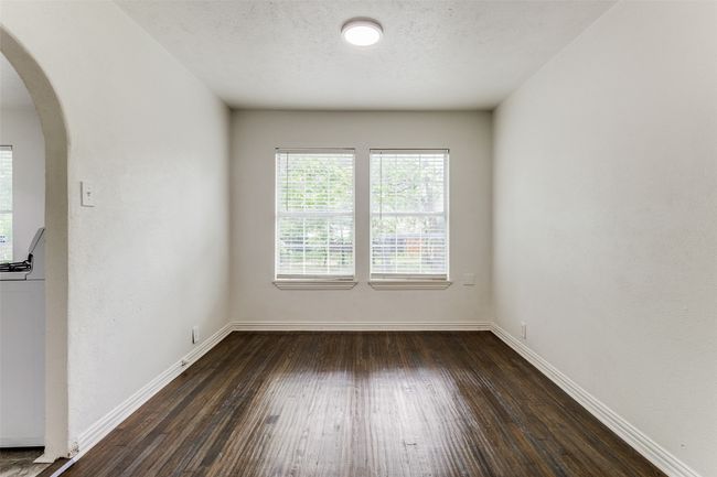 Empty room with arched walkways, dark wood-type flooring, washer / clothes dryer, and a textured ceiling | Image 10