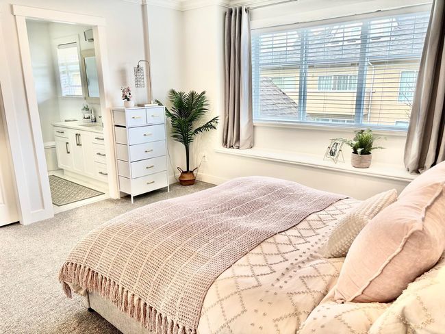 Bedroom with light colored carpet, multiple windows, ensuite bath, and ornamental molding | Image 15
