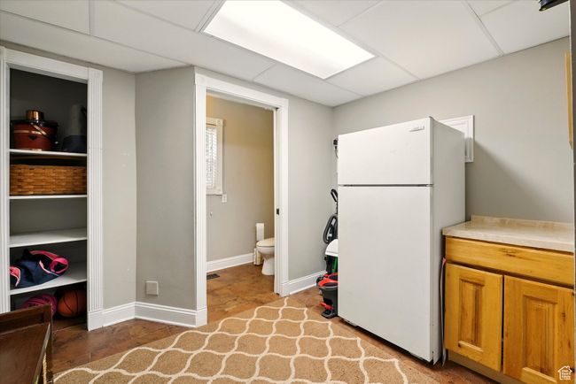 Kitchen with freestanding refrigerator, light countertops, and brown cabinetry | Image 28
