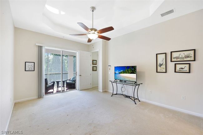 Expansive Master Bedroom featuring carpet flooring, ceiling fan, and a raised ceiling | Image 19