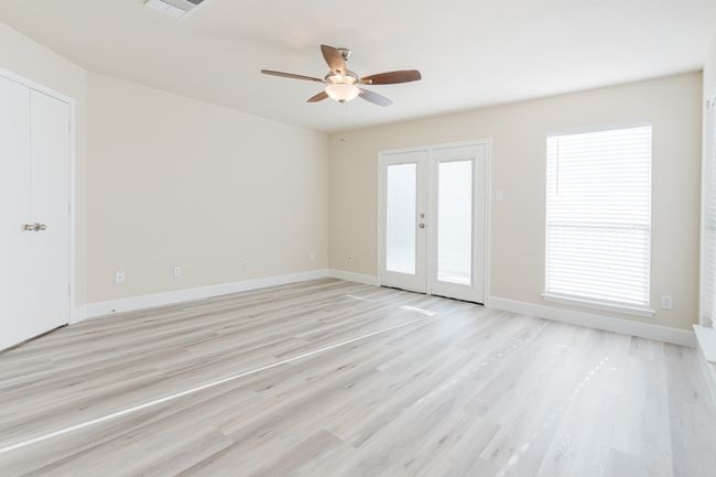 Spare room featuring light wood-type flooring, baseboards, a wealth of natural light, and french doors | Image 15