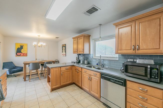 Unit 4900 Kitchen with sink, decorative light fixtures, kitchen peninsula, stainless steel appliances, and decorative backsplash | Image 9