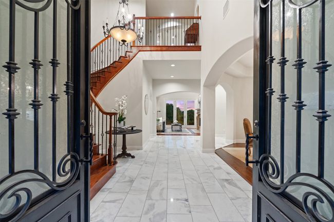 Entryway with a towering ceiling, arched walkways, stairs, baseboards, and light marble finish flooring | Image 5