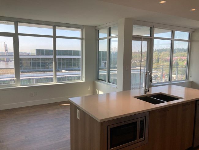 Kitchen with stainless steel microwave, light countertops, a healthy amount of sunlight, and a sink | Image 9