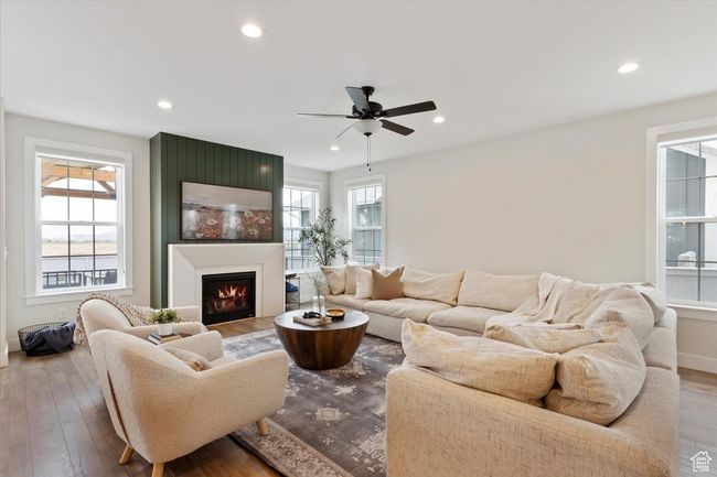 Living area with baseboards, recessed lighting, a large fireplace, ceiling fan, and hardwood / wood-style flooring | Image 8