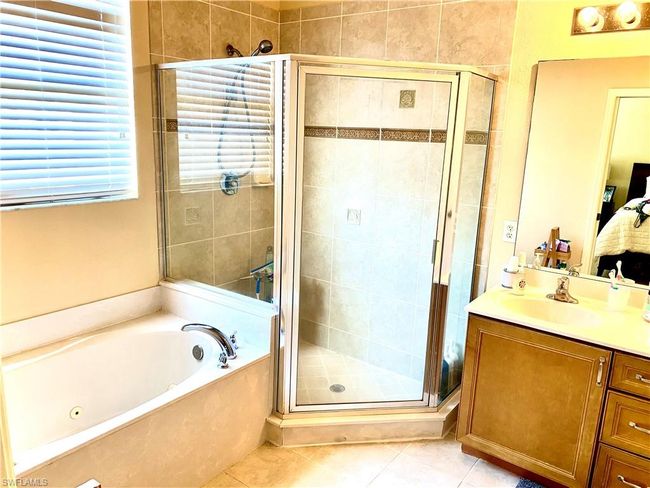 Bathroom featuring tile patterned floors, a shower stall, a garden tub, vanity, and connected bathroom | Image 13