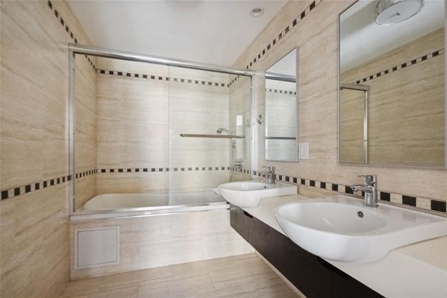 Full bathroom featuring tasteful backsplash, a sink, tile walls, and double vanity | Image 9