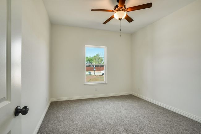 Carpeted empty room with a ceiling fan and baseboards | Image 23