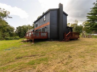 Rear view of house featuring a deck and a lawn | Image 1