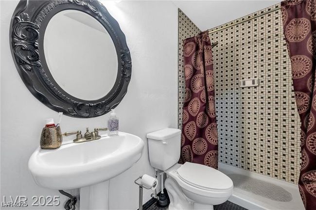 Bathroom featuring a shower stall, toilet, and a sink | Image 13
