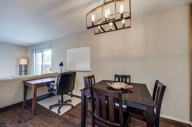 Dining room featuring wood finished floors, baseboards, and a chandelier | Image 7