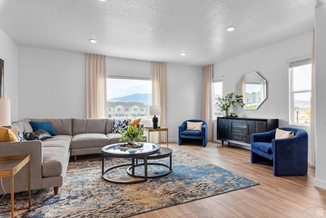 Living room featuring wood finished floors, a textured ceiling, and recessed lighting | Image 5