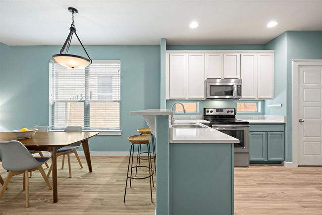 The breakfast bar between the dining area and kitchen provides a convenient spot for quick meals, casual conversations, or serving up drinks while keeping the flow between the two spaces effortless and connected | Image 13